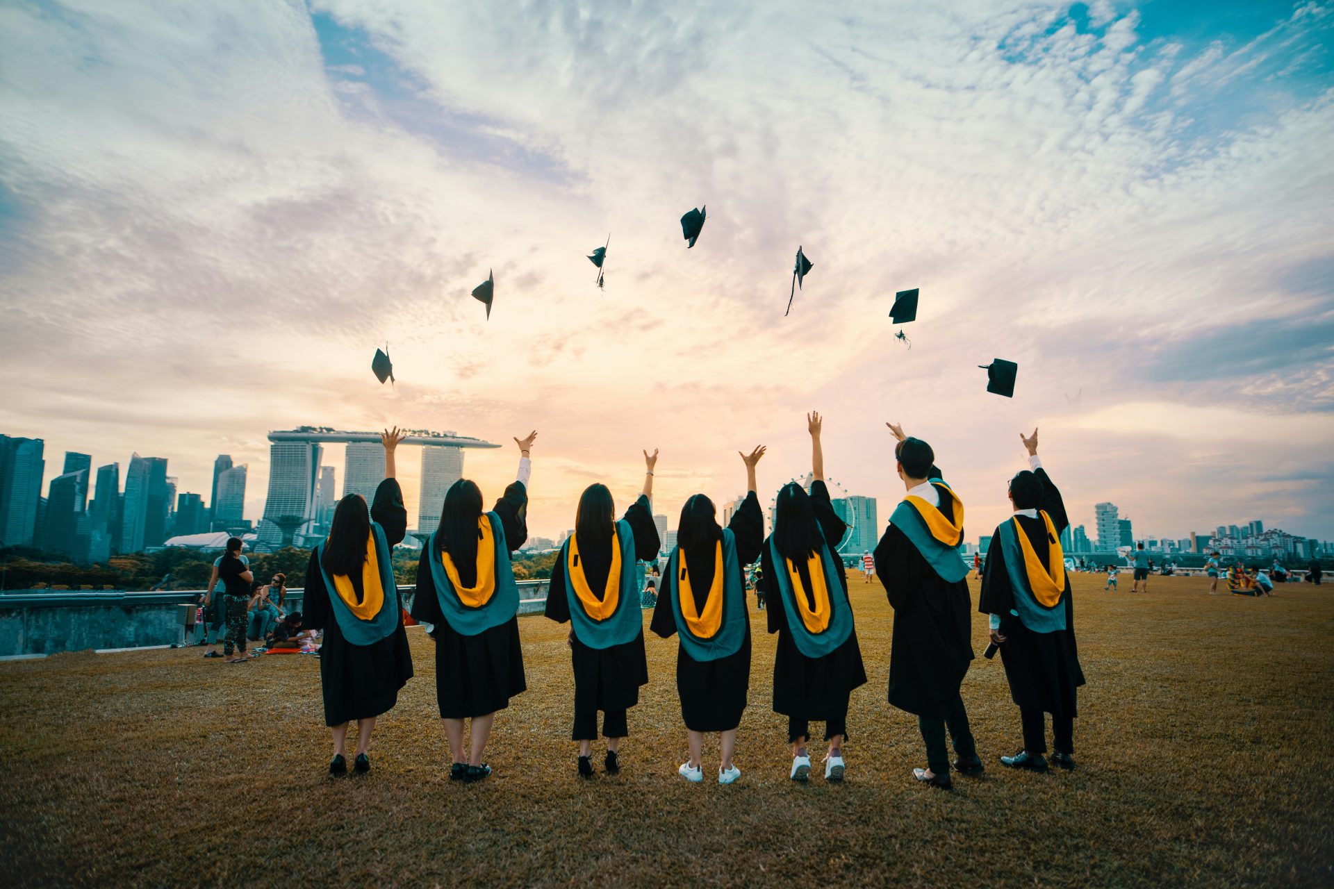 Graduates celebrating by throwing caps into sky.