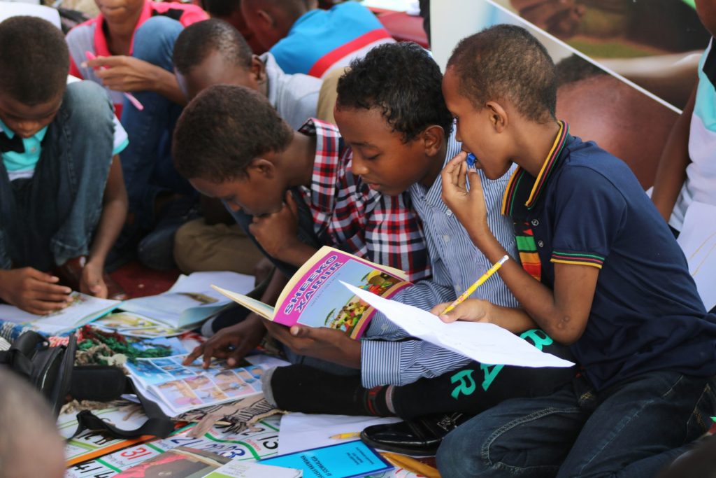 Children reading and studying together outdoors